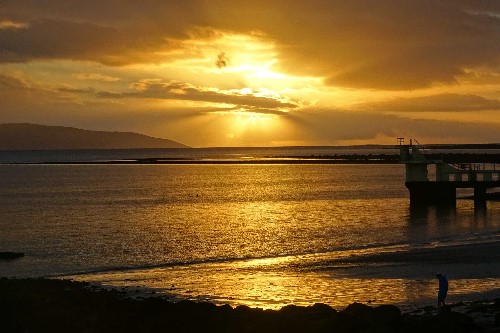 Powerful bursts of yellow rushing out through the clouds, encapsulating the whole of Salthill, Co. Galway