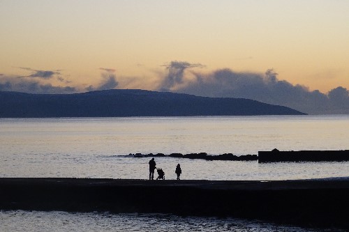 A child standing in awe at the sunset although at a distance you can feel his appreciation