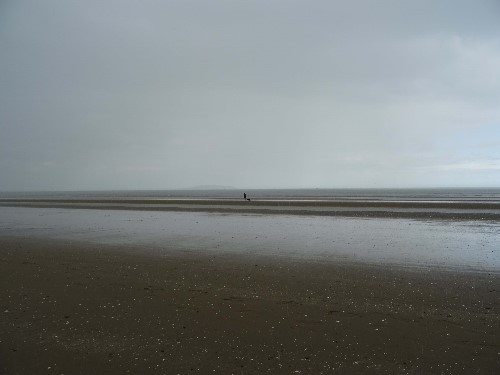 A lady waliking from a clear sky onto a storm