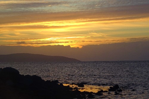 A golden yellow sunset at the end of a pier