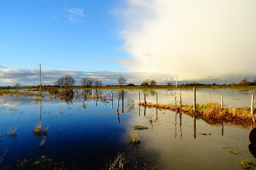 On the left it is pefectly blue sky & the rightside with a dark dreary cloud both reflected in the water